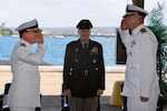 U.S. Navy Cmdr. Thomas Poe, right, incoming commander of Defense Logistics Agency Troop Support Indo-Pacific, and Navy Capt. Ryan Cullinan, left, outgoing commander, participate in a change of command ceremony as U.S. Army Brig. Gen. Sean P. Kelly, commander of DLA Troop Support, center, observes the traditional transfer of authority. The ceremony, held June 5, 2026, marks the formal relinquishment of command from Cullinan to Poe. DLA Troop Support Indo-Pacific provides comprehensive logistics, supply, and support services to joint warfighters across the Pacific theater. U.S. Navy photo by Wesley Burgos, public affairs specialist, NAVSUP FLC Pearl Harbor.