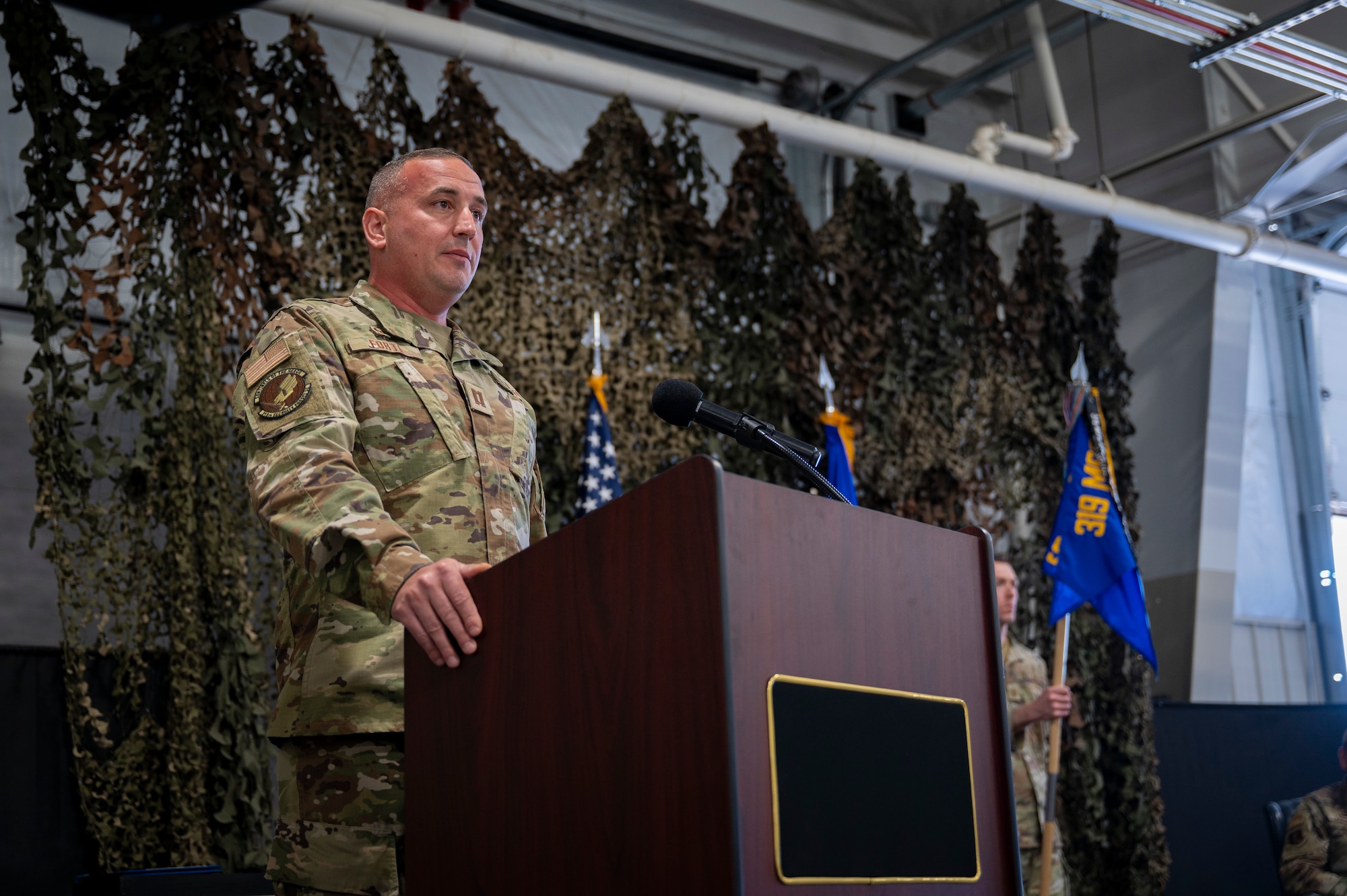 A man wearing a military uniform gives a speech while standing in front of a podium.