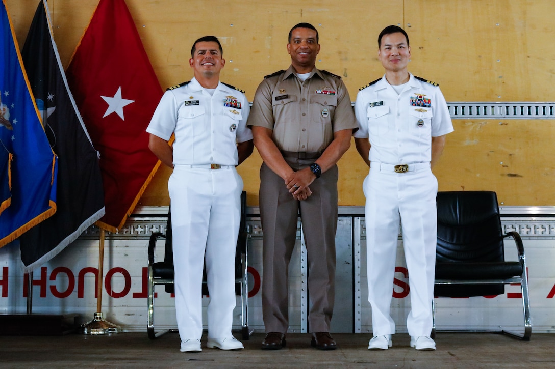 People wearing military uniforms stand on a stage