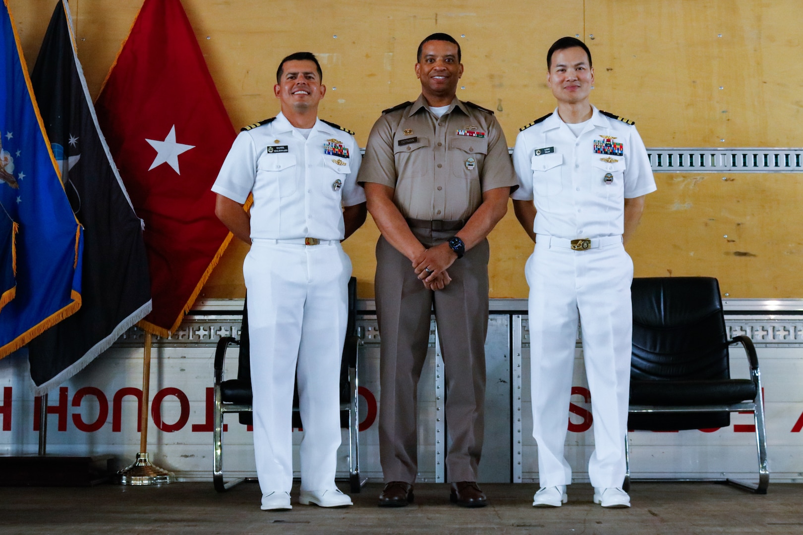 People wearing military uniforms stand on a stage