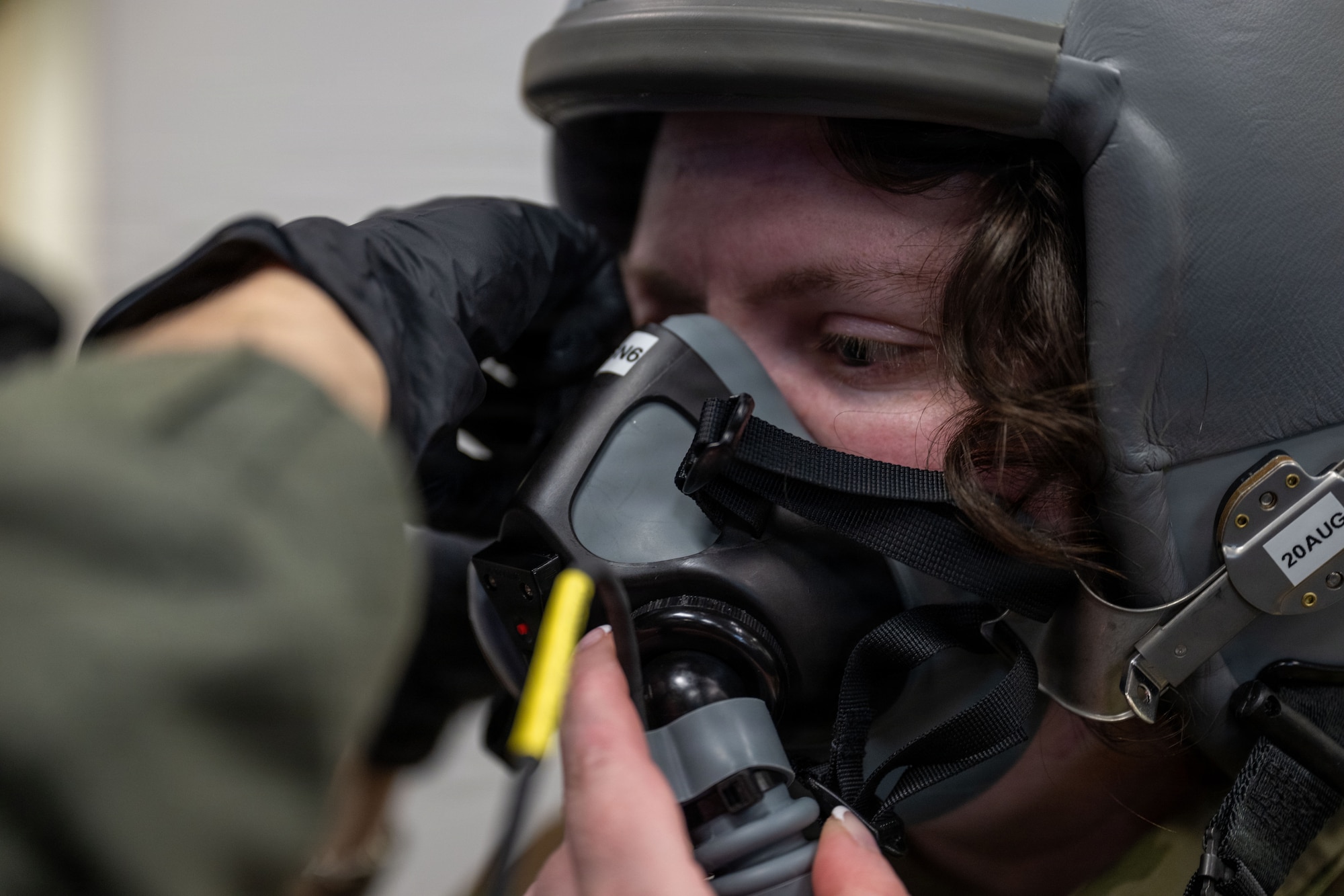 A woman receives help putting a mask on.