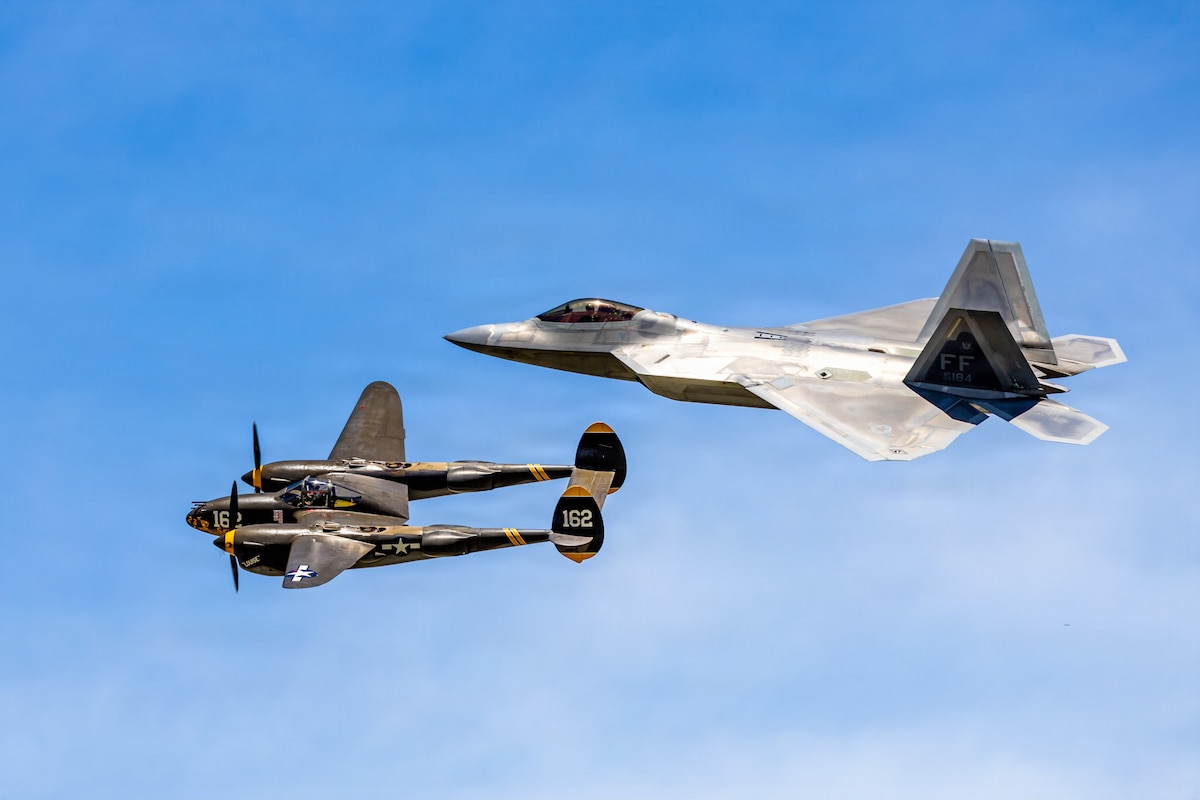 A P-38 Lightning and F-22 Raptor perform a heritage flight formation during the annual Dayton Air Show at the Dayton International Airport, Ohio, June 13, 2026. Heritage flights are symbolic aerial performances showcasing the past, present, and future of aviation and airpower. (U.S. Air Force photo by Daniel Peterson)