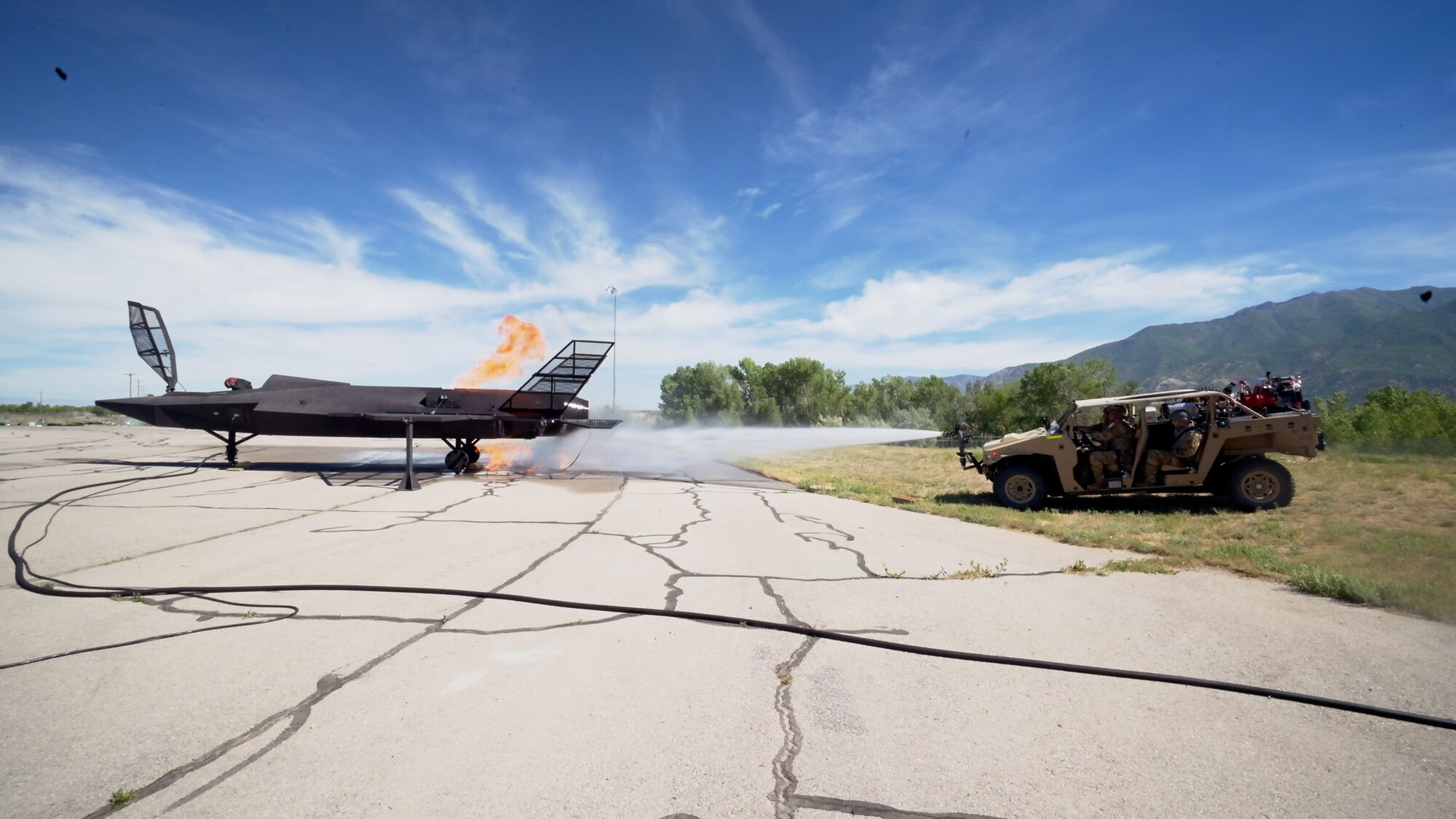 The MARK 1 sprays water at a fiery F-35 training prop.