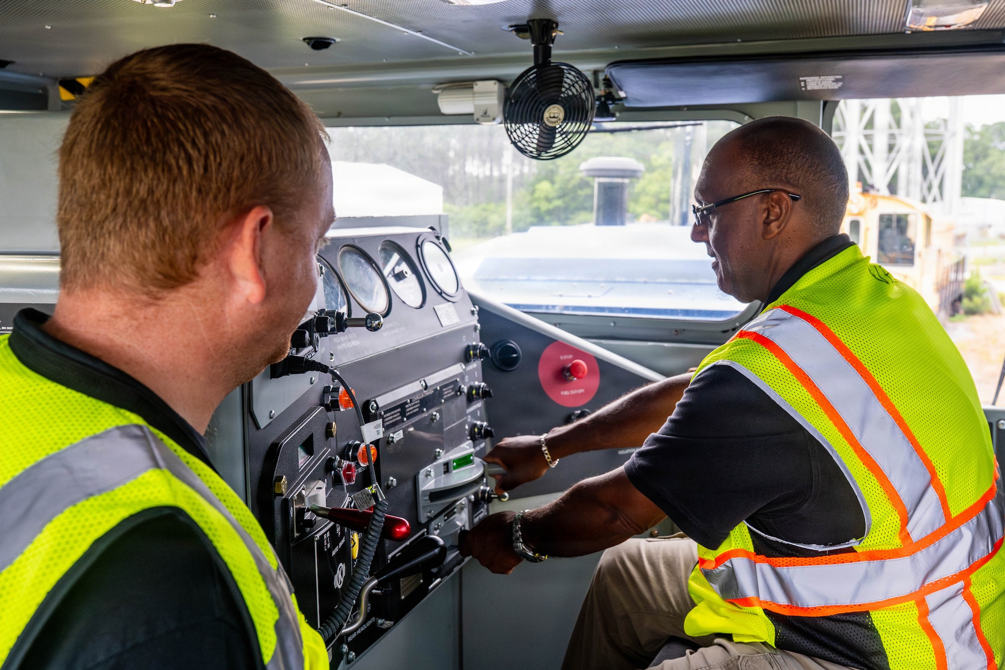 A photo of two men working on a locomotive.