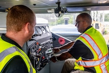 A photo of two men working on a locomotive.