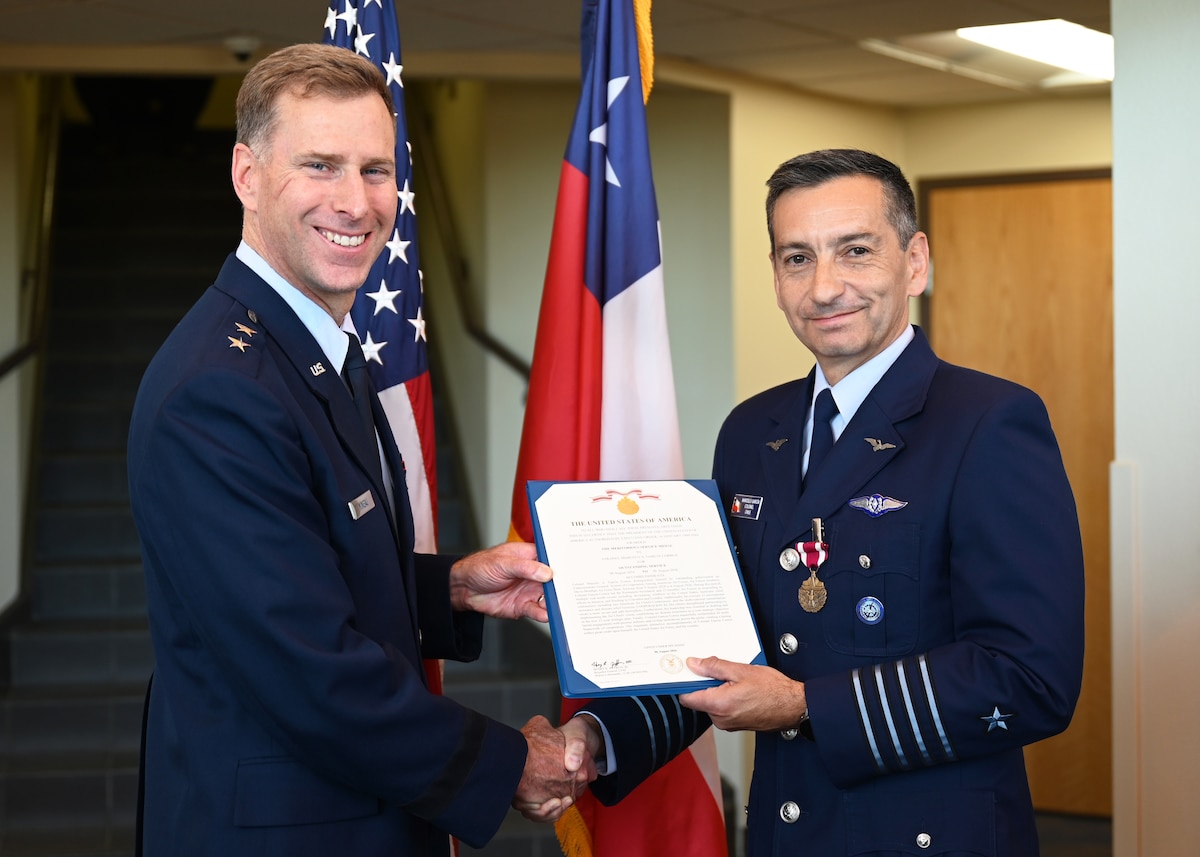 U.S. Air Force Maj. Gen. David Mineau, 12th Air Force, Air Forces Southern (AFSOUTH) commander, left, presents the Air Force Meritorious Service Medal citation to Chilean air force Col. Marcelo Garcia, System of Cooperation Among the American Air Forces (SICOFAA) undersecretary general, right, during a ceremony at Davis-Monthan Air Force Base, Arizona, June 5, 2026. Garcia received the medal in recognition of his leadership in strengthening cooperation among partner nation air forces to address shared regional challenges across the Western Hemisphere. (U.S. Air Force photo by Staff Sgt. Abbey Rieves)