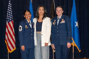 Three people stand and smile for a group photo