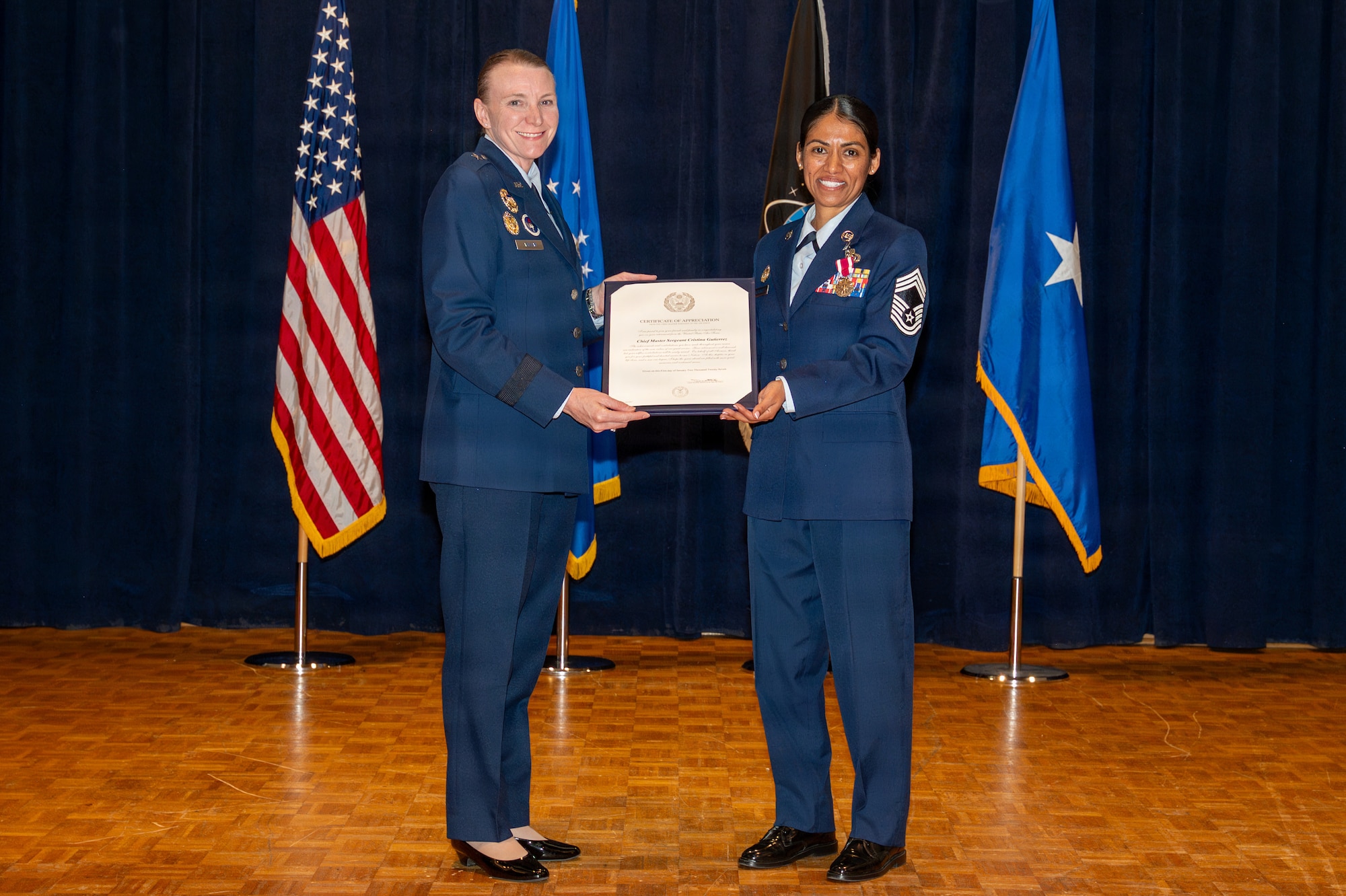Two people stand and hold a certificate