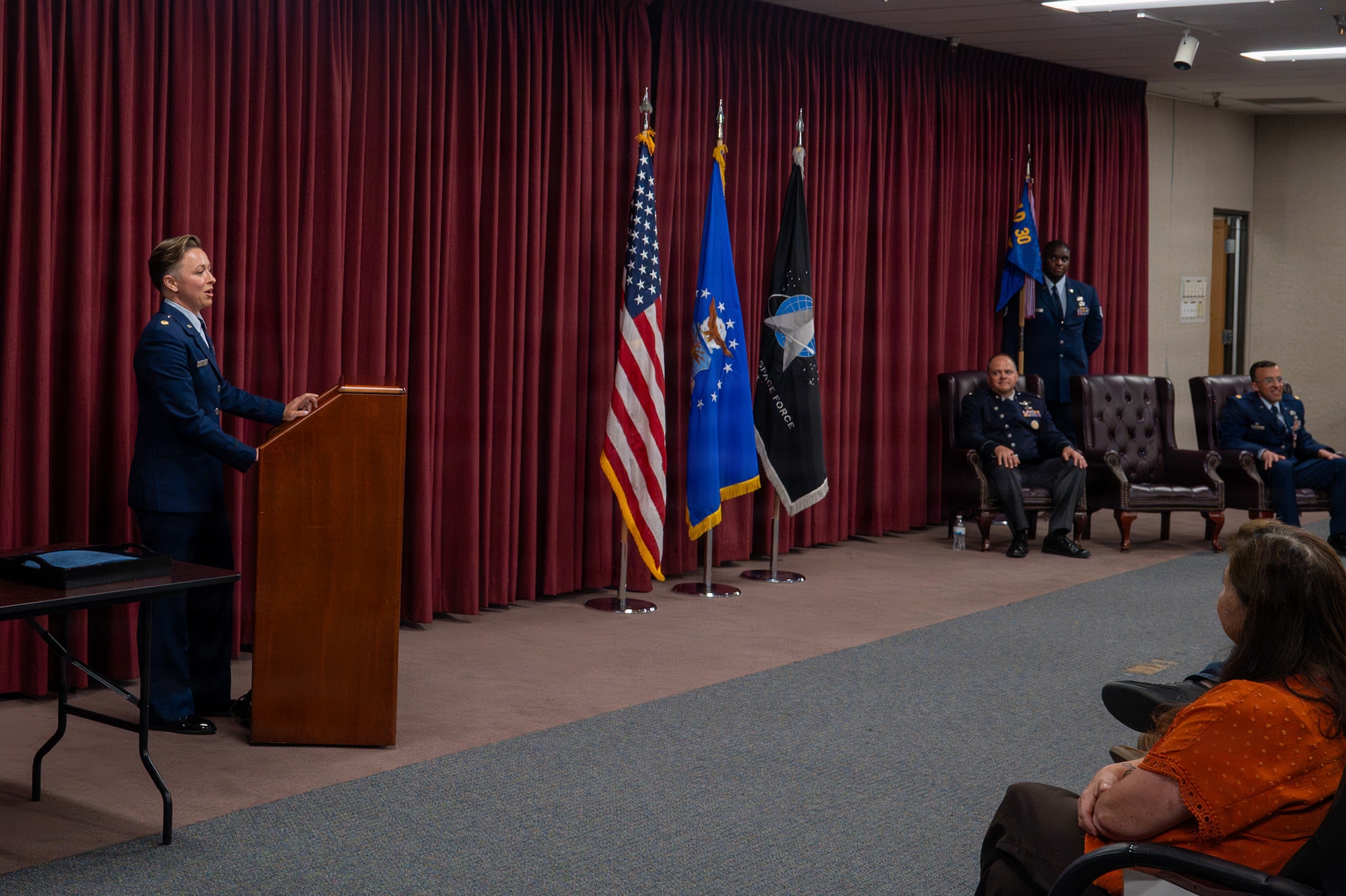 A person stands behind a podium and speaks