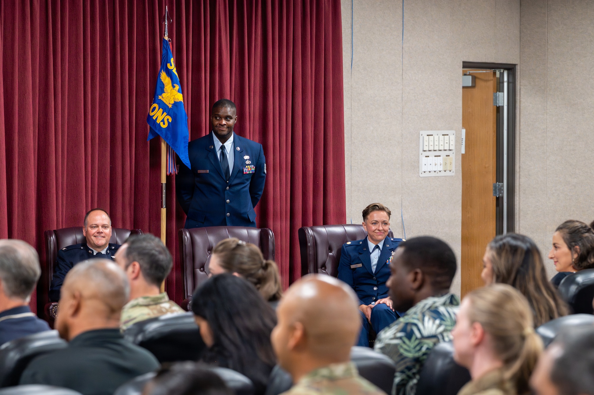 A crowd of people sit and listen to a speech