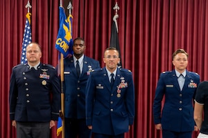 Four people stand at attention