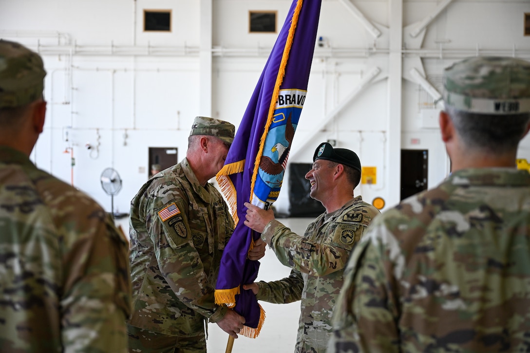 U.S. Army Command Sgt. Maj. John Diggles, outgoing Joint Task Force-Bravo senior enlisted leader, passes the JTF-Bravo guidon to Col. Robert Snyder, outgoing JTF-Bravo commander, during the JTF-Bravo change of command and responsibility ceremony at Soto Cano Air Base, Honduras, June 18, 2026. Diggles passing the guidon symbolizes his relinquishment of responsibility for JTF-Bravo, ending his time as the senior enlisted leader. (U.S. Air Force photo by Staff Sgt. Ethan Sherwood)