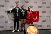 U.S. Army Capt. Jake Malven, left, U.S. Army Col. Chris Leung, center, and U.S. Marine Corps Master Sgt. Modesto Garcia, right, celebrate winning silver, gold and bronze respectively during the powerlifting competition at the 2026 Warrior Games at the Henry B. González Convention Center in San Antonio, Texas, June 13, 2026.