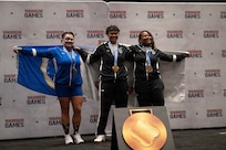 Retired U.S. Air Force Chief Master Sgt. Danielle Spurlock, left, U.S. Army Sgt. Tukiau Salanoa-Tuioti, center, and retired U.S. Army Sgt. 1st Class Valerie Watkins, right celebrate after winning silver, gold and bronze respectively during the powerlifting competition at the 2026 Warrior Games at the Henry B. González Convention Center in San Antonio, Texas, June 13, 2026.
