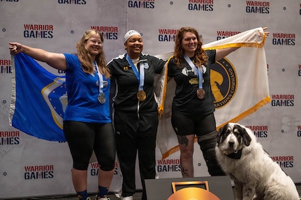 Retired U.S. Air Force Maj. Lillian Warner, left, U.S. Army Capt. Channda Mitchell, center, and U.S. Army Sgt. Ann Knox, right celebrate winning silver, gold, and bronze respectively during the powerlifting competition at the 2026 Warrior Games.