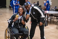 U.S. Army 1st Lt. Jani Merritt, left, and U.S. Army Capt. Tony Smith celebrate after winning medals during the powerlifting competition at the 2026 Warrior Games at the Henry B. González Convention Center in San Antonio, Texas.