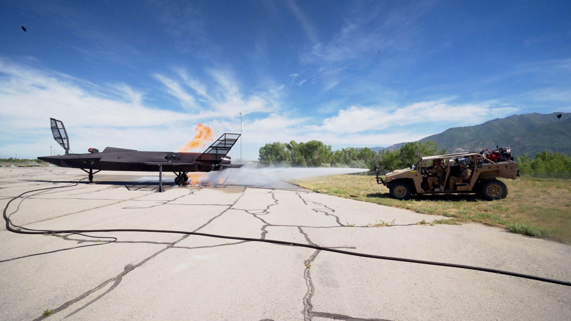 The MARK 1 sprays water at a fiery F-35 training prop.