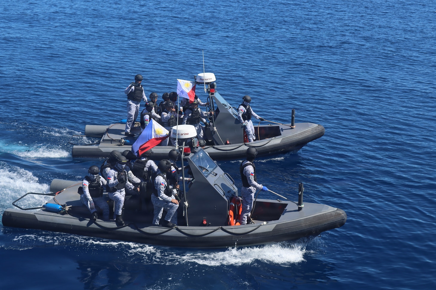 Members of the Armed Forces of the Philippines conduct small-boat operations with U.S. Coast Guard Sentinel-class fast response cutters USCGC Emlen Tunnell (WPC 1145) and Charles Moulthrope (WPC 1141) during a Maritime Cooperative Activity. U.S. 7th Fleet routinely operates with the Armed Forces of the Philippines and partners and allies through MCAs to continually develop, exercise and enhance multi-domain tactical interoperability to uphold peace and security in the region. (Courtesy photo by U.S. Coast Guard)