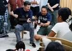 OLONGAPO CITY, Philippines (June 12, 2026) – U.S. Navy Capt. Robert Reyes, right, mission commander of Pacific Partnership 2026 (PP26), and U.S. Navy Chief Musician James Choate, assigned to PP26, sing to children during a PP26 community outreach and engagement event at the Olongapo Social Development Center in Olongapo City, Philippines, June 12, 2026.