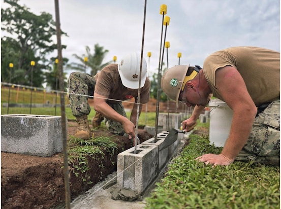 SAVUSAVU, Fiji (May 25, 2026) – U.S. Navy Lt. Cmdr. Rhett Johnson, left, and Builder 2nd Class Savage Milikin, assigned to Naval Mobile Construction Battalion (NMCB) 1, place a block for the Nabua Schoolhouse Project as part of Pacific Partnership 2026 in Savusavu, Fiji, May 25, 2026.