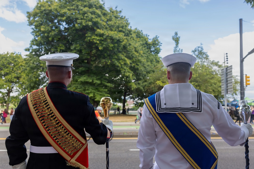 U.S. Marine Corp Gunnery Sgt. Craig Palmer, a drum master with the1st Marine Division Band, left, and U.S. Navy PO1 Everett Cenvich, a drum master with Navy Band Northwest, pose for a group photo at the Grand Floral Starlight Parade during the Portland Rose Festival Fleet Week, in Portland, Oregon, June 6, 2026. The Portland Rose Festival was a part of Portland Fleet Week and provided the opportunity to build community relations for the citizens of Oregon to interact with Marines, Sailors and Coast Guardsmen. Palmer is a native of Tennessee. Cenvich is a native Colorado. (U.S. Marine Corps photo by Cpl. Stella Tedesco)