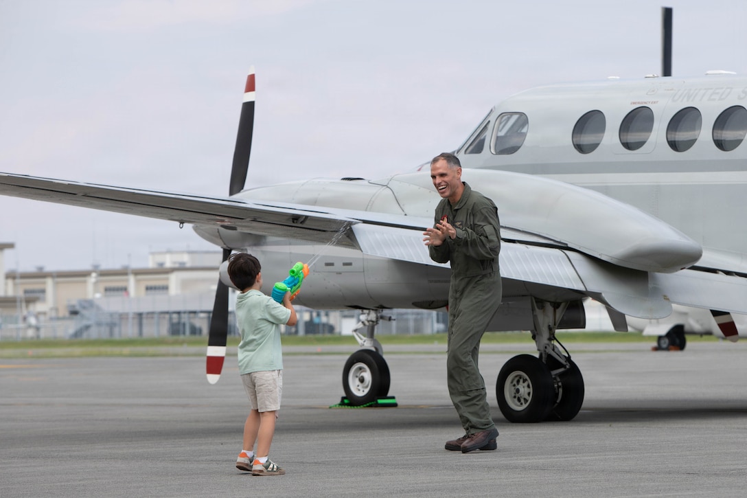 U.S. Marine Corps Lt. Col. Federico Mendizabal, the former commanding officer of Headquarters and Headquarters Squadron (H&HS), Marine Corps Air Station Iwakuni, and a native of East Aurora, New York, celebrates with his son after his final flight at MCAS Iwakuni, Japan, June 12, 2026. A commander’s final flight is a long-standing aviation tradition marking the end of their tour of duty. (U.S. Marine Corps photo by Lance Cpl. Kenneth Garcia)