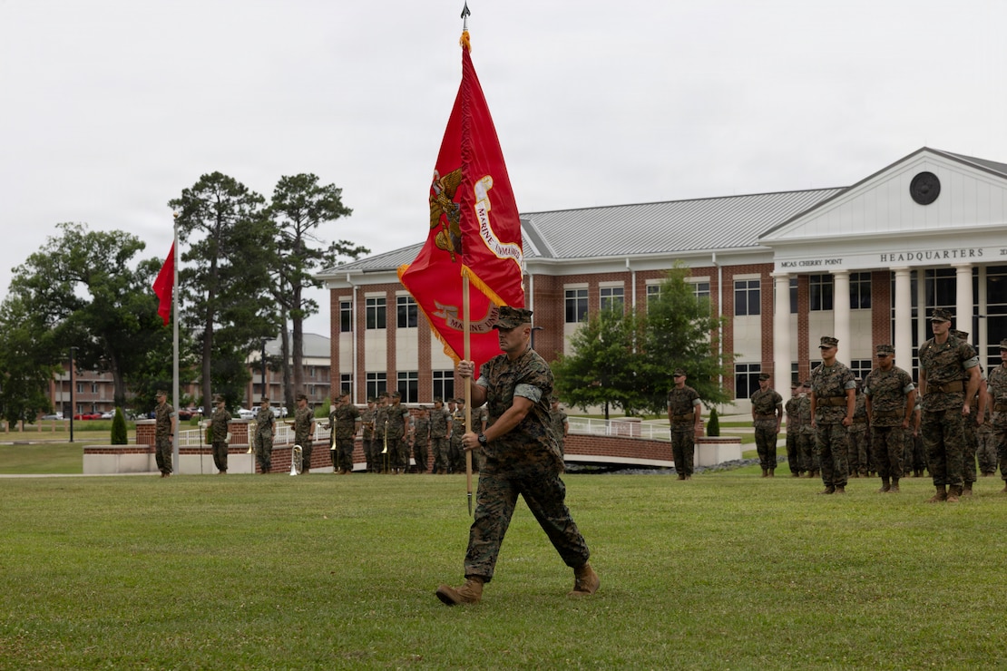 U.S. Marine Corps Sgt. Maj. Ryan N. McCrary, from Virginia, the command senior enlisted leader of Marine Aircraft Group 14, 2nd Marine Aircraft Wing, delivers the squadron colors during the Marine Unmanned Maintenance Squadron (MUMS) 14 activation ceremony at Marine Corps Air Station Cherry Point, North Carolina, June 16, 2026. MUMS-14 serves as the principal provider of organic level maintenance support for the U.S. Marine Corps Group 5 Unmanned Aerial Systems (UAS) operational and training fleet system of systems. (U.S. Marine Corps photo by Pfc. Keani Guthmueller)