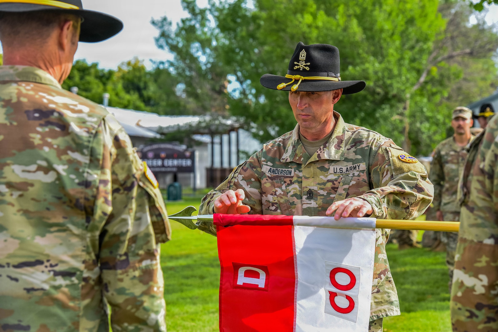 1st Sgt. Robert Anderson, inaugural first sergeant of D Company, 2nd Battalion, 116th Cavalry Regiment, unfurls the D Company guidon during the activation ceremony of D Company, 2nd Battalion, 116th Cavalry Regiment, June 18, 2026, at Gowen Field, Boise, Idaho.