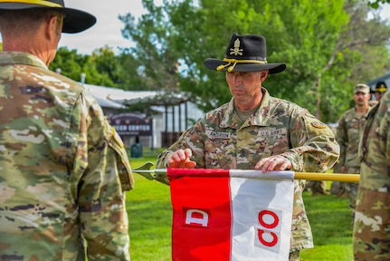 1st Sgt. Robert Anderson, inaugural first sergeant of D Company, 2nd Battalion, 116th Cavalry Regiment, unfurls the D Company guidon during the activation ceremony of D Company, 2nd Battalion, 116th Cavalry Regiment, June 18, 2026, at Gowen Field, Boise, Idaho.