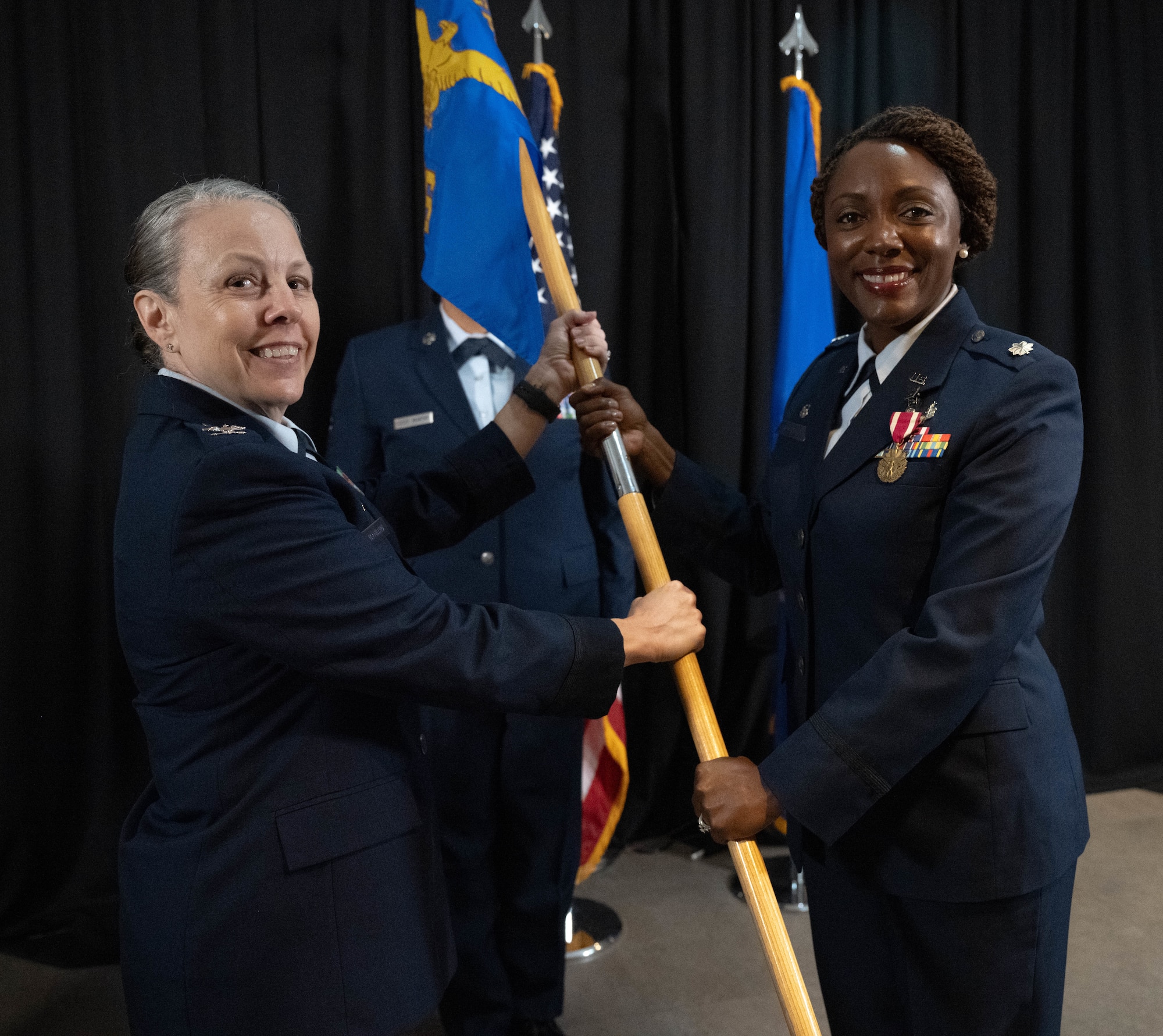 U.S. Air Force Col. Kelly Vermillion, Laughlin Medical Group commander, left, receives the squadron guidon from Lt. Col. Avis McCaslin, outgoing Laughlin Operational Medical Readiness Squadron (LOMRS) commander, during the LOMRS change of command ceremony at Laughlin Air Force Base, Texas, June 18, 2026. In a change of command ceremony, the guidon symbolizes the transfer of command, as well as the authority and responsibility associated with it. (U.S. Air Force photo by Airman 1st Class Darryl Keith)