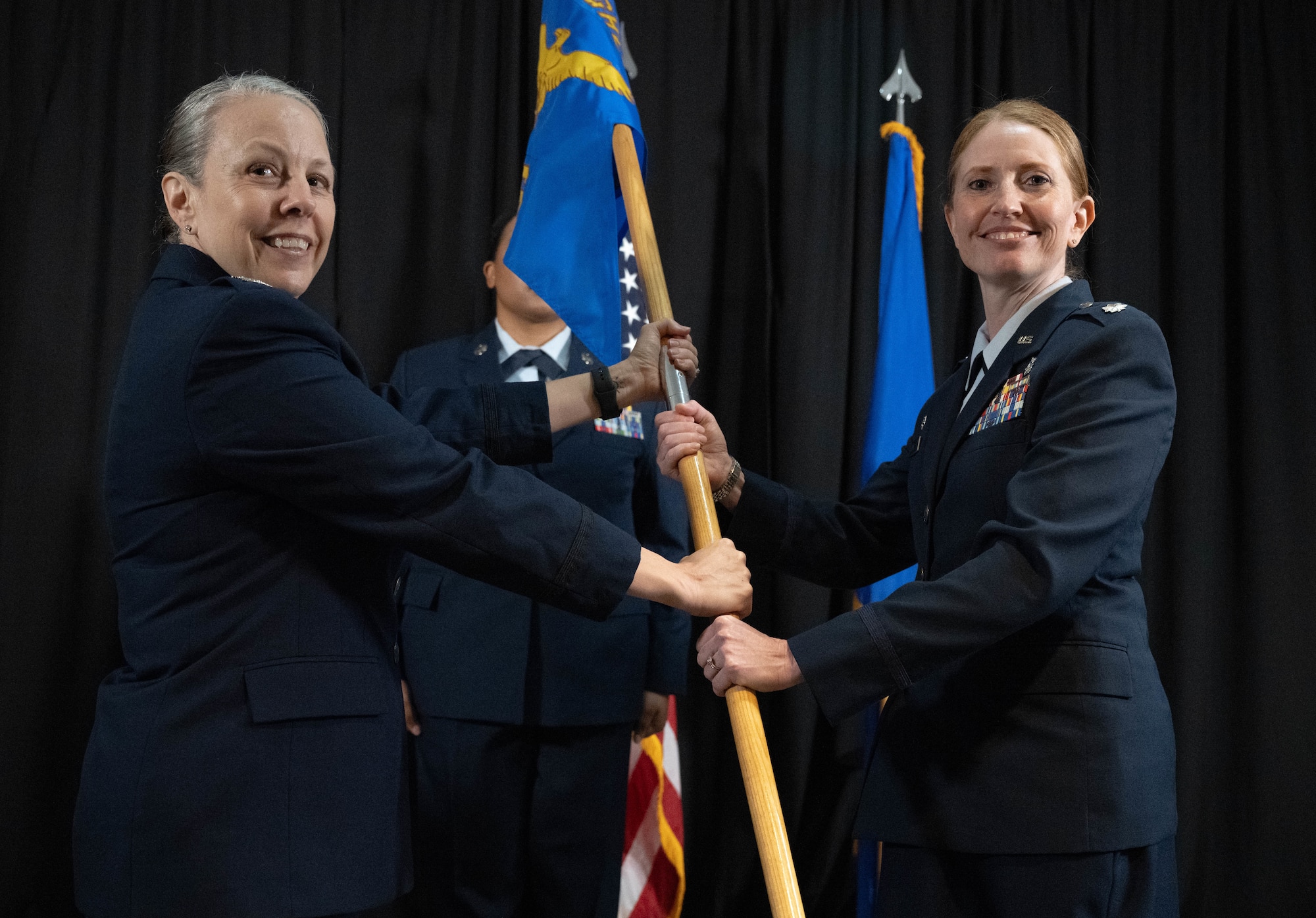 U.S. Air Force Col. Kelly Vermillion, Laughlin Medical Group commander, left, presents the squadron guidon to Lt. Col. Katrina Dyke, incoming Laughlin Operational Medical Readiness Squadron (LOMRS) commander, during the LOMRS change of command ceremony at Laughlin Air Force Base, Texas, June 18, 2026. In a change of command ceremony, the guidon symbolizes the transfer of command, as well as the authority and responsibility associated with it. (U.S. Air Force photo by Airman 1st Class Darryl Keith)