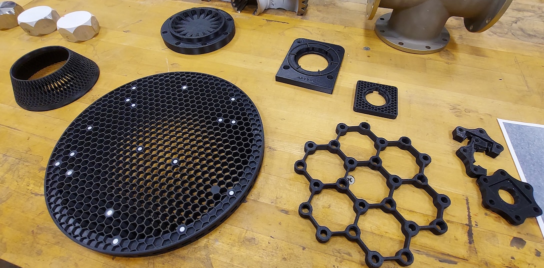 Items which have been 3D printed on display on a yellow wood table.
