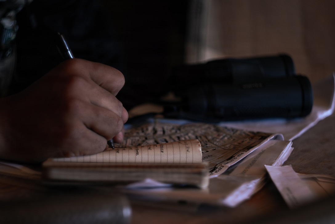 A U.S. Marine Corps scout with 2nd Battalion, 24th Marines, 4th Marine Division, notes simulated enemy movements from a listening and observing post as part of an information and intelligence integration course during Integrated Training Exercise 3-26, Marine Corps Air Ground Combat Center Twentynine Palms, California, June 8, 2026. ITX is designed to generate combat readiness and ensure the Reserve Component provides critical strategic depth to the Total Force. From complex combined arms maneuvers to all-domain integration, these Marines are proving that they are ready to augment, reinforce, and fight alongside the active component at a moment's notice. (U.S. Marine Corps photo by Cpl. Van Hoang)