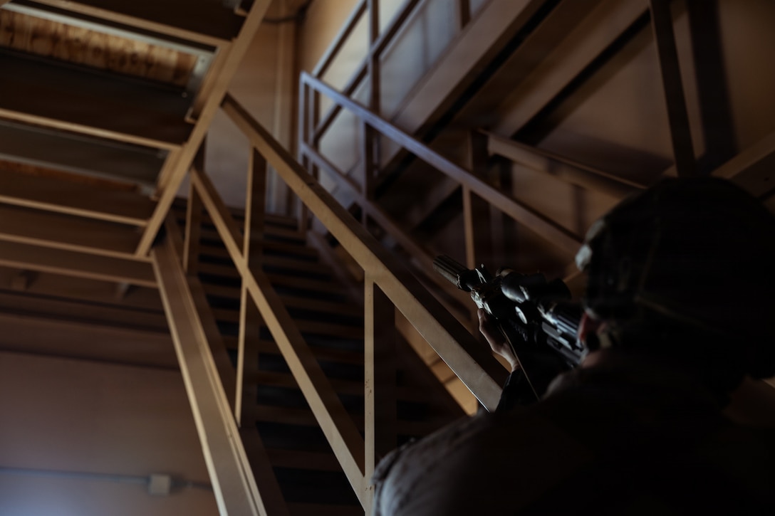 A U.S. Marine Corps scout with 2nd Battalion, 24th Marines, 4th Marine Division, secures a stairwell in a military operation on urban terrain town as part of an information and intelligence integration course during Integrated Training Exercise 3-26, Marine Corps Air Ground Combat Center Twentynine Palms, California, June 8, 2026. ITX is designed to generate combat readiness and ensure the Reserve Component provides critical strategic depth to the Total Force. From complex combined arms maneuvers to all-domain integration, these Marines are proving that they are ready to augment, reinforce, and fight alongside the active component at a moment's notice. (U.S. Marine Corps photo by Cpl. Van Hoang)