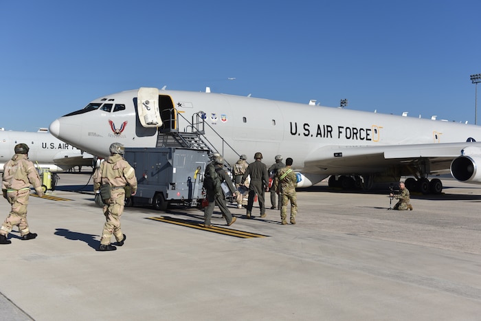 Military personnel getting on an airplane