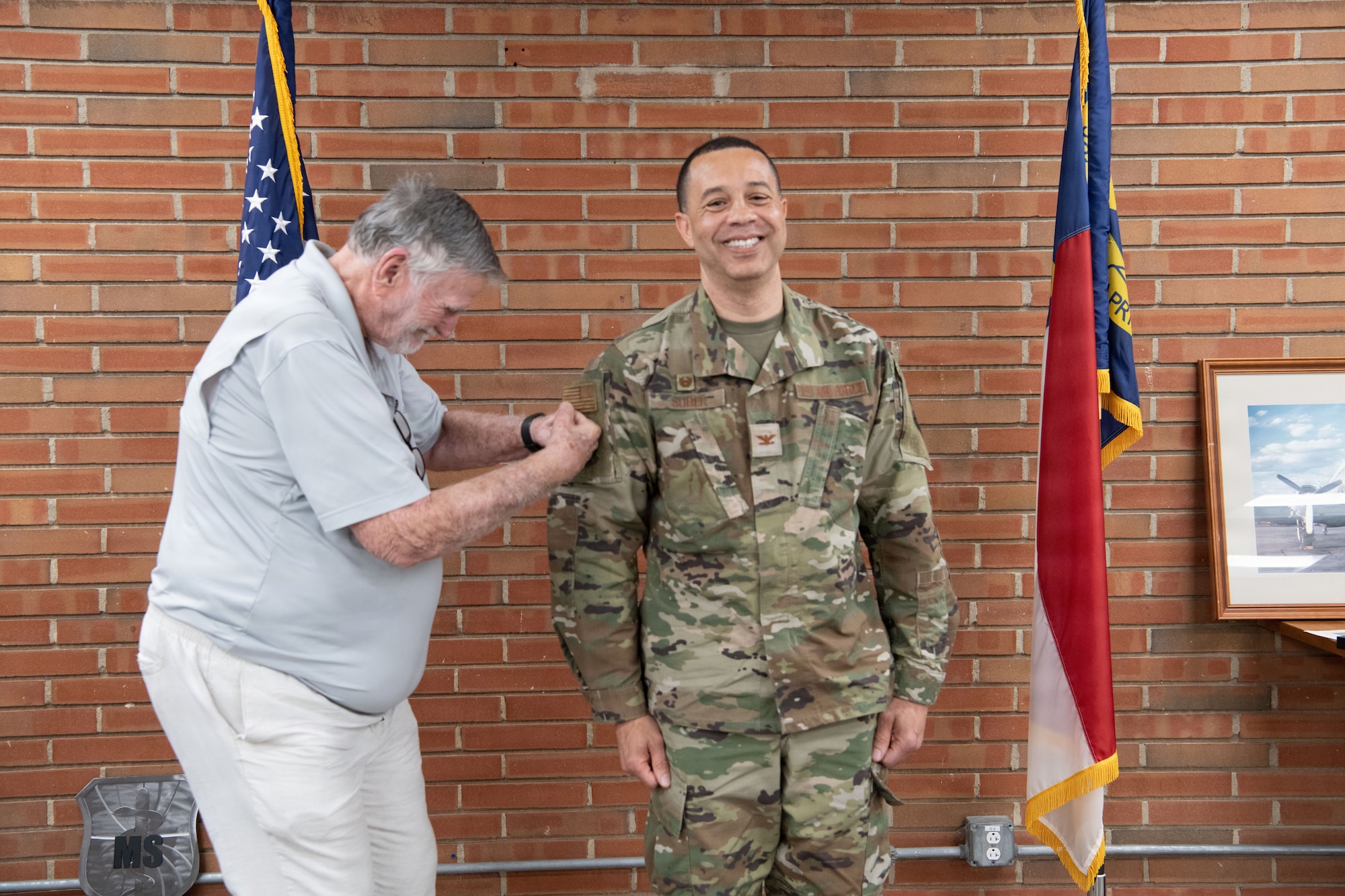 U.S. Air Force Col Shawn Suber, 156th Aeromedical Evacuation Squadron Commander, receives the new patch for the squadron from SMSgt (ret) Jim Brookes, during an emblem dedication ceremony on 6 June 2026 at the Charlotte Air National Guard base, N.C.