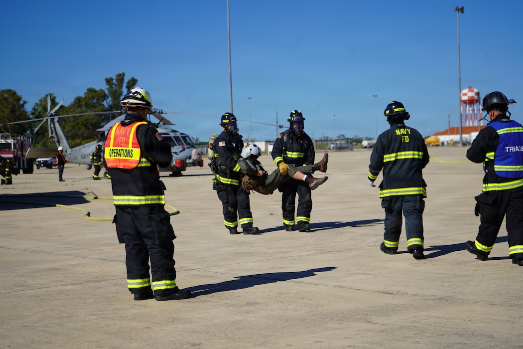 Fire and Emergency Services personnel transport a simulated casualty during an Air Mishap exercise at Naval Station Rota, May 20, 2026. The exercise brought together first responders and medical personnel from Naval Medical Readiness and Training Command (NMRTC) Rota to practice casualty triage, patient movement, and emergency response procedures in a realistic training environment. The training enhanced coordination among responding agencies and strengthened the readiness of Navy Medicine personnel to provide lifesaving care and medical support during operational, contingency, and emergency response missions. (U.S. Navy photo by Lt. Vanessa Bernales)