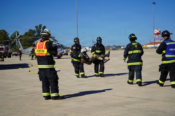 Fire and Emergency Services personnel transport a simulated casualty during an Air Mishap exercise at Naval Station Rota, May 20, 2026. The exercise brought together first responders and medical personnel from Naval Medical Readiness and Training Command (NMRTC) Rota to practice casualty triage, patient movement, and emergency response procedures in a realistic training environment. The training enhanced coordination among responding agencies and strengthened the readiness of Navy Medicine personnel to provide lifesaving care and medical support during operational, contingency, and emergency response missions. (U.S. Navy photo by Lt. Vanessa Bernales)