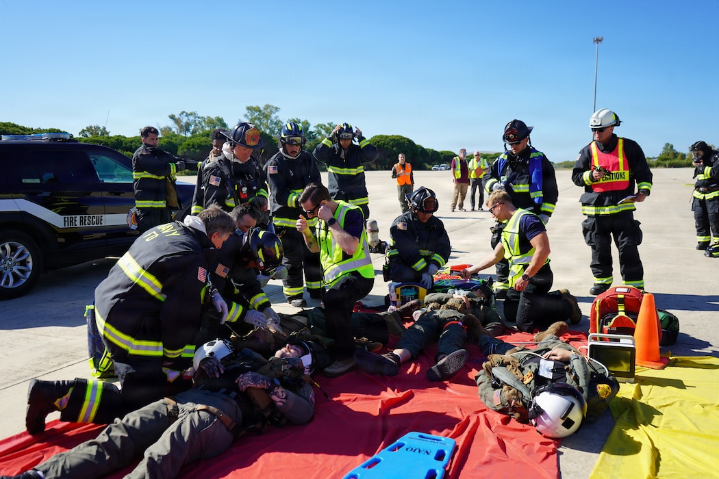 Fire and Emergency Services personnel transport a simulated casualty during an Air Mishap exercise at Naval Station Rota, May 20, 2026. The exercise brought together first responders and medical personnel from Naval Medical Readiness and Training Command (NMRTC) Rota to practice casualty triage, patient movement, and emergency response procedures in a realistic training environment. The training enhanced coordination among responding agencies and strengthened the readiness of Navy Medicine personnel to provide lifesaving care and medical support during operational, contingency, and emergency response missions. (U.S. Navy photo by Lt. Vanessa Bernales)