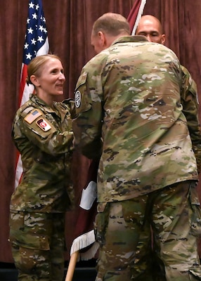 Brig. Gen. James “Jamie” Burk, Commanding General of Medical Readiness Command, East, passes the Fort Meade Medical Department Activity unit colors to Col. Elizabeth "Betsy" A. DeSitter, incoming commander of the Meade MEDDAC and director of Kimbrough Ambulatory Care Center