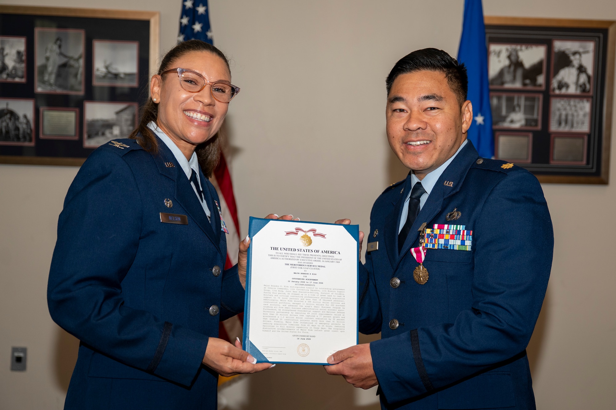U.S. Air Force Col. Angelique Nelson, 11th Mission Support Group commander, left, presents U.S. Air Force Maj. Brandon K. Kido, 11th Contracting Squadron outgoing commander, with a Meritorious Service Medal during the 11th CONS change of command ceremony at Joint Base Anacostia-Bolling, Washington, D.C., June 17, 2026. Kido was responsible for leading the 11th CONS in their support to the 11th Wing, 75 JBAB mission partners and more than 17,000 military and civilian employees and their families throughout the National Capital Region. (U.S. Air Force photo by Senior Airman Shanel Toussaint)