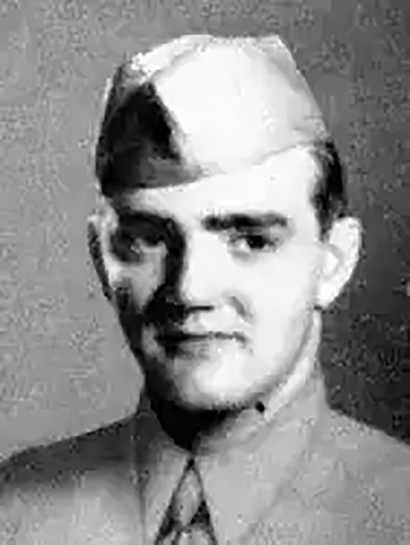 A man in a formal military uniform smiles for a photo.