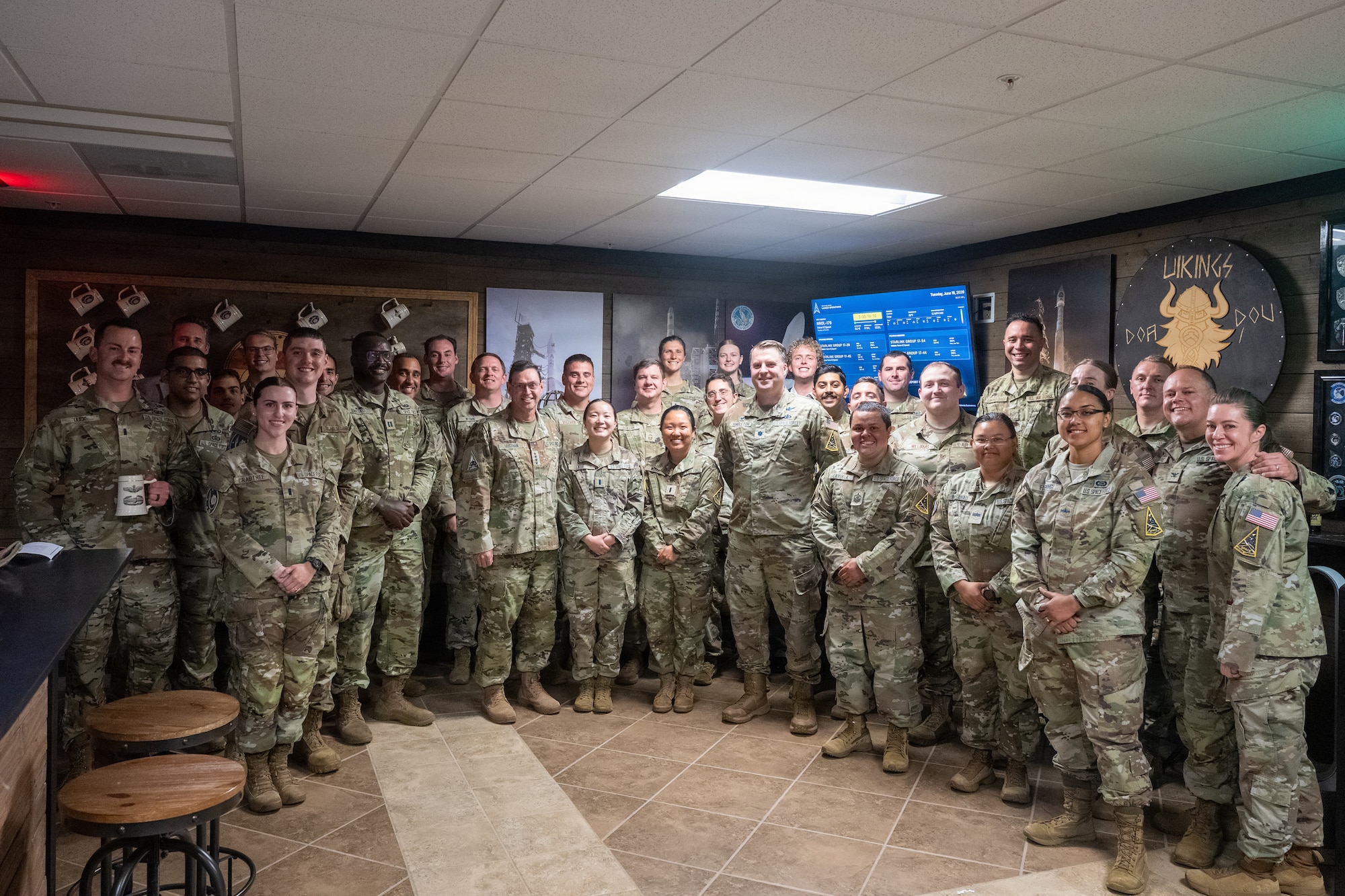 The 2nd Space Launch Squadron group up to pose with the general in their Viking style heritage room.
