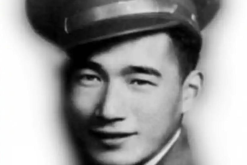 A black and white photo of a man wearing a military dress uniform and hat posing for a photo.