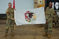 1st Lt. Colin Kehoe, who will lead the approximately 70 Soldiers of the 233rd Military Police Co. on its deployment to Alaska, displays the State of Illinois Flag with Maj. Gen. Rodney Boyd, The Adjutant General of Illinois and Commander of the Illinois National Guard, during the unit’s June 7 mobilization ceremony on Camp Lincoln in Springfield.