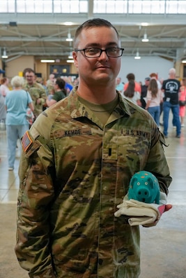 1st Lt. Colin Kehoe will lead the approximately 70 Soldiers of the 233rd Military Police Co. on its deployment to Alaska where the Soldiers will protect infrastructure critical to the security of the United States of America. He stands with War Pig, the element’s mascot, during the company’s mobilization ceremony, June 7, on Camp Lincoln in Springfield.