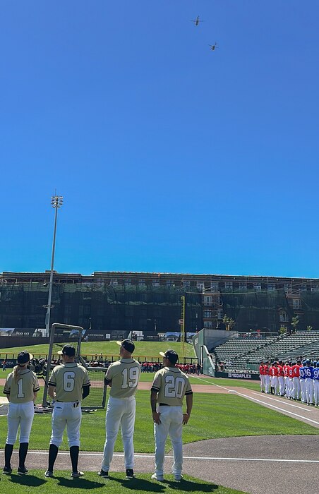 Utah National Guard and Hill Air Force Base players stand along the first-base line as helicopters fly over The Ballpark at America First Square before an exhibition baseball game in South Jordan, Utah, June 13, 2025. The game followed the "In the Open: Strength Beyond the Uniform" resilience event, which focused on mental health awareness, resilience and community support. (Utah National Guard photo by Master Sgt. Nicholas Perez)