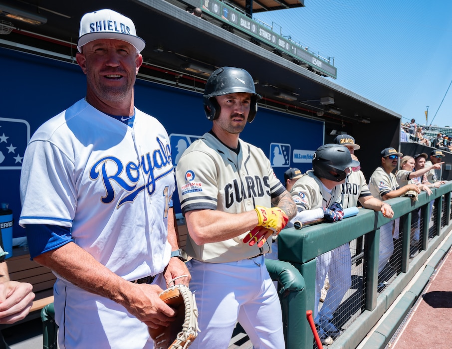 Retired Major League Baseball catcher and Utah National Guard team coach John Buck (left) stands with members of the Utah National Guard baseball team in the dugout before an exhibition game against Hill Air Force Base at The Ballpark at America First Square in South Jordan, Utah, June 13, 2025. The game followed the "In the Open: Strength Beyond the Uniform" resilience event, which promoted mental health awareness, community engagement and service member well-being. (Utah National Guard photo by Master Sgt. Nicholas Perez)
