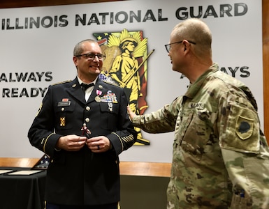 State Command Chaplain (Colonel) Steve Foster congratulates 1st Sgt. (ret.) Greg Hoffman career during Hoffman’s June 6 retirement ceremony on Camp Lincoln in Springfield, Illinois.