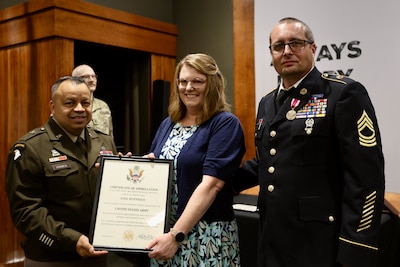 Brig. Gen. Jorge Fonseca, the Director of the Illinois National Guard Joint Staff, presents Jodi Hoffman with a Certificate of Appreciation signed by the U.S. Army Chief of Staff thanking her for her support of her husband, Illinois Army National Guard 1st Sgt. (ret.) Greg Hoffman, throughout his 27-year military career during Greg Hoffman’s June 6 retirement ceremony on Camp Lincoln in Springfield, Illinois.
